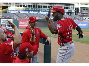 Los Angeles Angels' Brian Goodwin, right, is congratulated after hitting a two-run home run against the Texas Rangers during the first inning of a baseball game Monday, April 15, 2019, in Arlington, Texas.