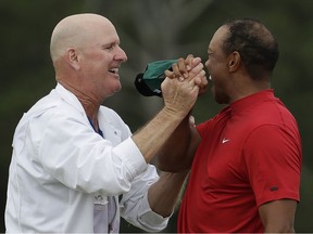 Tiger Woods reacts with his caddie Joe LaCava as he wins the Masters golf tournament Sunday, April 14, 2019, in Augusta, Ga.