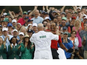 Tiger Woods reacts with his caddie Joe LaCava as he wins the Masters golf tournament Sunday, April 14, 2019, in Augusta, Ga.