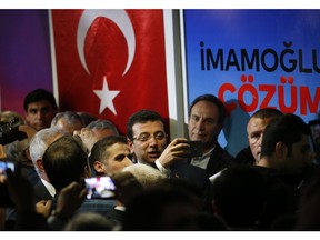 Ekrem Imamoglu, centre, the opposition, Republican People's Party's (CHP) mayoral candidate in Istanbul, is photographed by a supporter following a media conference in Istanbul, Tuesday, April 9, 2019. Turkey's President Recep Tayyip Erdogan's ruling Justice and Development Party, or AKP, says it will seek a re-run of last week's mayoral election in Istanbul, citing alleged irregularities. The party suffered a major setback in the elections. Opposition candidates won in Turkey's capital, Ankara, and squeezed out the ruling party in Istanbul.