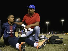 Antonio Velasquez, right, a pastor and director of the Maya Chapin soccer league, talks with player William Sebastian, 16, left, during a break in a soccer league game Wednesday, April 17, 2019, in Phoenix.