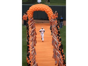Baltimore Orioles manager Brandon Hyde (18) runs down the orange carpet during introductions before a baseball game between the Orioles and the New York Yankees, Thursday, April 4, 2019, in Baltimore.