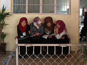 In this Feb. 26, 2019 photo, women wait for legal advice in a legal clinic supported by the Norwegian Refugee Council, in west Mosul, Iraq. Thousands of Iraqi families face crushing social and legal discrimination -- all because of the choices their male relatives made under the Islamic State group's rule. They've been disowned by relatives and abandoned by the state.