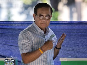 FILE - In this March 24, 2019, file photo, Thailand's Prime Minister Prayuth Chan-ocha prepares to cast his vote at a polling station in Bangkok, Thailand, during the nation's first general election since the military seized power in a 2014 coup. Prayuth looks set to return as prime minister after a general election stacked heavily in his favor, but the process reveals that more than a decade's polarization in Thai politics is as strong as ever.