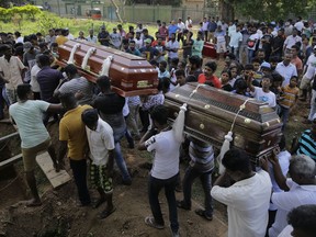 FILE - In this Tuesday, April 23, 2019, file photo, Sri Lankans carry the coffins carrying victims of the Easter Sunday bombings in Colombo, Sri Lanka. The U.S. ambassador says America had "no prior knowledge" of a threat in Sri Lanka before the Easter bombings that killed more than 350 people.