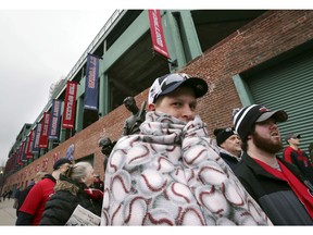 Nolan Granbusch, of Dallas, arrives at Fenway Park bundled against the cold for the home opener baseball game between the Boston Red Sox and the Toronto Blue Jays, Tuesday, April 9, 2019, in Boston.