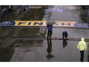 Final preparations are made in the rain at the finish line for the 123rd Boston Marathon on Monday, April 15, 2019, in Boston.