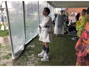 Lukas Chmatal, 35, originally from the Czech Republic and now a scientist at Massachusetts Institute of Technology, waits under a tent while it rains before the start of the 123rd Boston Marathon on Monday, April 15, 2019, in Hopkinton, Mass.