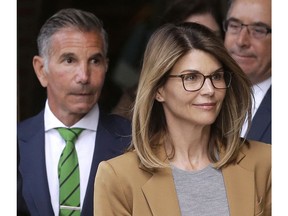 FILE - In this April 3, 2019 file photo, actress Lori Loughlin, front, and husband, clothing designer Mossimo Giannulli, left, depart federal court in Boston after facing charges in a nationwide college admissions bribery scandal. On Tuesday, April 9, Loughlin and Giannulli were among 16 prominent parents indicted on an additional charge of money laundering conspiracy in the case.