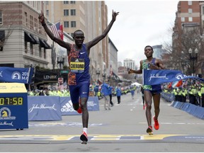 Lawrence Cherono, of Kenya, breaks the tape to win the 123rd Boston Marathon in front of Lelisa Desisa, of Ethiopia, right, on Monday, April 15, 2019, in Boston.