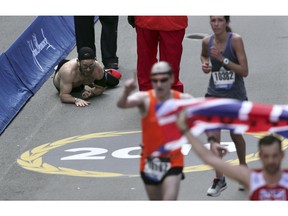 Micah Herndon, of Tallmadge, Ohio, crawls to the finish line in the 123rd Boston Marathon on Monday, April 15, 2019, in Boston.