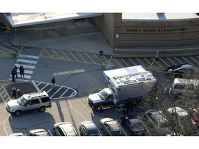 FILE - In this Dec. 14, 2012, aerial file photo, officials stand outside of Sandy Hook Elementary School in Newtown, Conn., where gunman Adam Lanza opened fire inside school killing 20 first-graders and six educators at the school. A Connecticut appeals court is scheduled to hear arguments on Wednesday, April 17, 2019, on whether parents of some of the shooting victims can sue the town for school officials' alleged failure to follow security protocols once the shooting began.