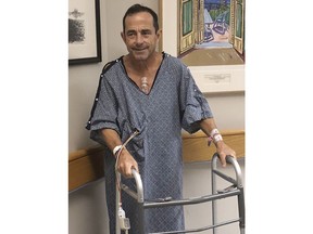 In this Oct. 14, 2018, photo provided by Katie McGillivray, Boston Marathon race director Dave McGillivray uses a walker after undergoing open-heart triple bypass surgery at Massachusetts General Hospital in Boston. McGillivray, a lifelong competitor, is cautioning people thinking of running a marathon to talk with their doctors before hitting the road, especially if they have coronary artery disease or a family history of it.