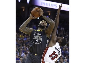 In this Feb. 10, 2019, file photo, Golden State Warriors' DeMarcus Cousins, left, shoots against Miami Heat center Bam Adebayo (13) during an NBA basketball game in Oakland, Calif. Cousins cannot wait for his playoff chance at last. He has anticipated this moment so many times and it never happened. That is why he approached the Warriors last summer and asked for a chance, even though he was working back from season-ending surgery for a torn left Achilles tendon. Cousins joined the two-time defending champions for $5.3 million and this very opportunity.