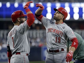 Cincinnati Reds' Joey Votto, right, celebrates with teammate Eugenio Suarez after hitting a home run during the first inning of the team's baseball game against the San Diego Padres on Thursday, April 18, 2019, in San Diego.