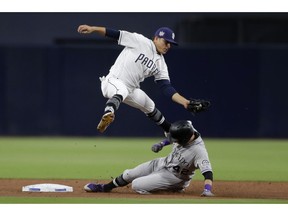 San Diego Padres second baseman Luis Urias, above, leaps over Colorado Rockies' Garrett Hampson who is caught stealing second base during the first inning of a baseball game Monday, April 15, 2019, in San Diego.