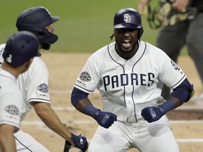 CORRECTS INNING TO SECOND INNING INSTEAD OF 22ND INNING - San Diego Padres' Franmil Reyes, right, reacts with teammates after hitting a two-run home run during the second inning of a baseball game against the Seattle Mariners, Tuesday, April 23, 2019, in San Diego.