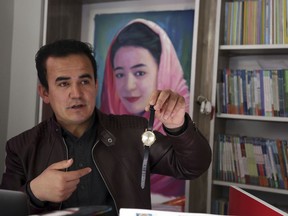 In this Tuesday, March 19, 2019, photo, Hameed Rafi, brother of the late Rahila, shows his sister's watch, during an interview with the Associated Press at the Rahila library, in Kabul, Afghanistan. Rafi says he'll never forget the day he joined a panel of civilian war victims and family members and spoke about the suicide bombing in Kabul that killed his sister last August.
