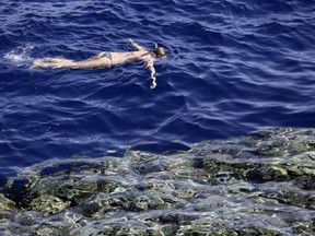 FILE - In this Nov. 7, 2015 file photo, a tourist swims in the Red Sea, at Sharm el-Sheikh, Egypt. An Egyptian official says his Red Sea province will impose a ban on disposable plastics, prohibiting everything from single use straws to plastic bags in an effort to fight plastic pollution. Ahmed Abdallah, governor of Hurghada province, said late on Tuesday, April, 2, 2019, that the ban will go into effect from June.