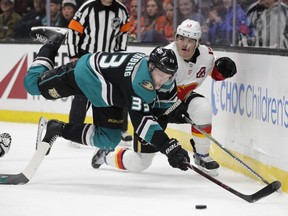 Anaheim Ducks' Jakob Silfverberg, left, of Sweden, loses his balance while moving the puck past Calgary Flames' Matthew Tkachuk during the first period of an NHL hockey game Wednesday, April 3, 2019, in Anaheim, Calif.