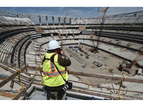 A photographer takes a photo of the new NFL Los Angeles Stadium while under construction during a topping-out ceremony in Inglewood, Calif. on Monday April 15, 2019. Stadium officials hosted a tour for the media after the final piece of the canopy structure to hold the roof was completed.