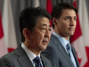 Canadian Prime Minister Justin Trudeau listens as Japanese Prime Minister Shinzo Abe speaks at a news conference in Ottawa.