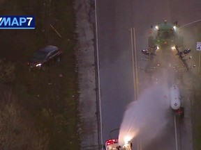 In this image made from video provided by ABC7 Chicago, a fire engine sprays water on a container of a chemical that farmers use for soil after anhydrous ammonia leaked Thursday, April 25, 2019, in Beach Park, Ill. Authorities say dozens of people have been taken to hospitals after anhydrous ammonia leaked from containers that a tractor was pulling in a Chicago suburb. (ABC7 Chicago via AP)