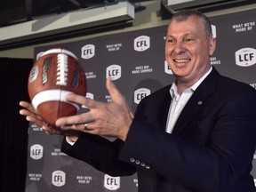 Randy Ambrosie tosses a football as he speaks during a press conference in Toronto on July 5, 2017.