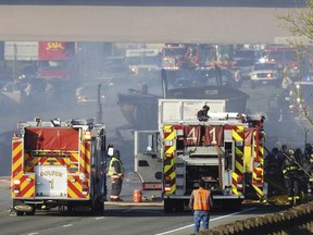 In this Thursday, April 25, 2019 photo, emergency crews work at the scene of a deadly collision on Interstate 70 near the Colorado Mills Parkway in Lakewood, Colo. On Friday, police said the truck driver blamed for causing the fatal pileup involving over two dozen vehicles has been arrested on vehicular homicide charges.