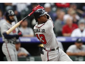 Atlanta Braves' Ronald Acuna Jr. follows the flight of his two-run home run off Colorado Rockies starting pitcher Kyle Freeland in the first inning of a baseball game Monday, April 8, 2019, in Denver.