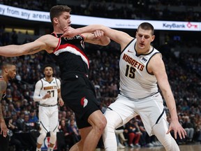 Denver Nuggets center Nikola Jokic, right, pushes off Portland Trail Blazers forward Meyers Leonard in the first half of Game 1 of an NBA basketball second-round playoff series Monday, April 29, 2019, in Denver.