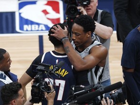 San Antonio Spurs guard DeMar DeRozan, right, hugs Denver Nuggets guard Jamal Murray after the second half of Game 7 of an NBA basketball first-round playoff series, Saturday, April 27, 2019, in Denver. The Nuggets won 90-86 to advance to the second round against Portland.