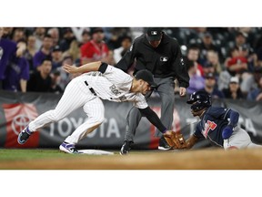 Colorado Rockies third baseman Nolan Arenado, left, tags out Atlanta Braves' Ronald Acuna Jr., who tried to advance from second to third on a passed ball during the eighth inning of a baseball game Tuesday, April 9, 2019, in Denver.