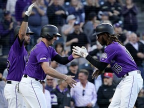 Colorado Rockies' Raimel Tapia (15) is congratulated by teammate Ryan McMahon (24) after hitting a two run home run against the Washington Nationals during the second inning of a baseball game Tuesday, April 23, 2019, in Denver.