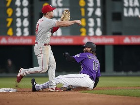 Philadelphia Phillies second baseman Scott Kingery throws to first after forcing out Colorado Rockies' Charlie Blackmon (19) during the third inning of a baseball game Thursday, April 18, 2019, in Denver. David Dahl was safe at first.