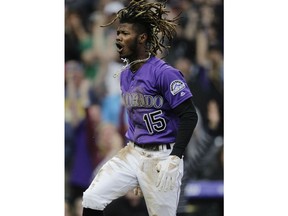 Colorado Rockies center fielder Raimel Tapia reacts after hitting an inside-the-park home run against the Philadelphia Phillies in the first inning of a baseball game in Denver, Saturday, April 20, 2019.