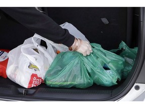 A shopper places her goods into her car outside a supermarket in Christchurch, New Zealand, Friday, Aug. 10, 2018. Newfoundland and Labrador has announced it will become the second province to ban plastic bags.