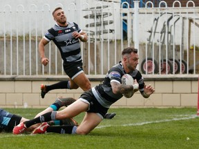 Toronto Wolfpack fullback Gareth O'Brien scores a try as Toronto teammate Matty Russell watches in the Wolfpack's Betfred Championship rugby league match Monday, April 22, 2019 against the Featherstone Rovers.