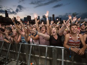 This Aug. 3, 2013 file photo shows fans reacting while Mumford & Sons performs at the Lollapalooza Festival in Chicago. While a feast of rock idols the likes of Aerosmith, Lynyrd Skynyrd and Nickelback dish out epic anthems at the Roxodus music festival this summer, a group of VIP concertgoers will be chowing down on a more lavish experience an earshot away.THE CANADIAN PRESS/AP/Scott Eisen, File