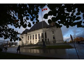 A pedestrian walks past the Supreme Court of Canada in Ottawa, Oct. 18, 2013. A murderer won't get a chance to argue in the Supreme Court that his conviction should be overturned because a rap lyric he wrote was improperly allowed into evidence.