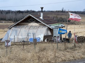 An unidentified man stands at a Mi'kmaq camp at the entrance to an Alton Gas work site along the Shubenacadie River, in Fort Ellis, N.S. on March 18, 2019. A court order has laid out a small patch of land where Aboriginal and other protesters will be permitted to voice their opposition to a plan to store natural gas in underground caverns north of Halifax.