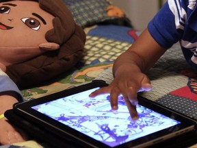 A child plays with an iPad in his bedroom in Metairie, La., on October 21, 2011. A new study links preschoolers who got two hours of screen time or more per day to behavioural problems they experienced at age five. The research looked at more than 2,400 families and compared children who got at least two hours of screentime daily to those who had less than 30 minutes per day.