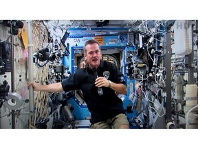 Canadian astronaut Chris Hadfield responds to a question during a news conference from the International Space Station on a photograph taken from a television monitor on January 10, 2013 in St-Hubert, Que. Canadian astronaut Chris Hadfield's famous photos from the International Space Station will soon be available to the public. Hadfield donated more than 13,000 photos to Dalhousie University in Halifax, where they will be preserved and offered for educational and research purposes.