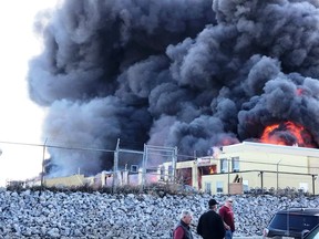 A fire burns at an industrial complex in Red Deer, Alta., in this Wednesday, April 17, 2019 handout photo. Residents from 80 homes in the central Alberta city of Red Deer have been asked to leave as a precaution due to a large industrial fire. Others in the Oriole Park and Oriole Park West neighbourhoods are being asked to stay inside to avoid thick black smoke from the blaze.