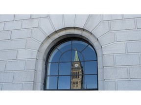 The Peace tower is reflected in a window in Ottawa, Tuesday March 26, 2019. A House of Commons committee says government should offer financial incentives to political parties that nominate more women candidates to run for election. This is one of 14 recommendations of the status of women committee, which studied the ongoing under-representation of women in politics.