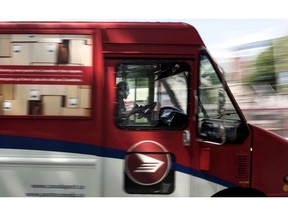 A Canada Post employee drives a mail truck through downtown Halifax on July 6, 2016. Parcel delivery is booming, but Canada Post will struggle to make a profit in coming years due to a continuing decline in letter mail, higher employee costs and billions in capital spending, says a corporate forecast quietly tabled in Parliament.