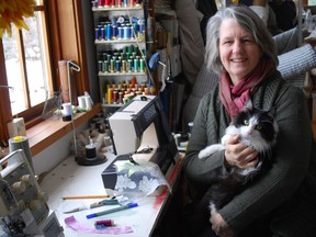 Sue Earle and her cat Louie pose for a photo in her sewing room on Salt Spring Island, B.C. in this undated handout photo. Elizabeth May chose Earth Day to get married and she wanted her wedding dress to be a garden of earthly delights. "She had an idea for a dress and she sketched it out for me," said May's dress designer Sue Earle of Salt Spring Island.