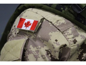 A Canadian flag patch is shown on a soldier's shoulder in Trenton, Ont., on Thursday, Oct. 16, 2014. The Canadian military isn't letting its hair down just yet, but for the first time, women in uniform will be allowed to wear ponytails.