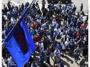 Fans wait to get inside the ballpark before the Chicago Cubs home opening baseball game against the Pittsburgh Pirates, Monday, April 8, 2019, in Chicago.