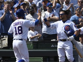 Chicago Cubs' Ben Zobrist (18) is greeted by Kyle Schwarber (12) after scoring against the Pittsburgh Pirates during the second inning of a baseball game, Monday, April 8, 2019, in Chicago.